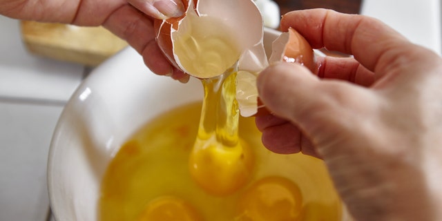 Three eggs are shown cracked into a bowl. The recipe described here from Casey Corn calls for three egg yolks.