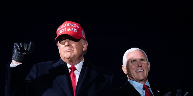 Then-President Donald Trump arrives with then-Vice President Mike Pence for a campaign rally at Cherry Capital Airport in Traverse City, Michigan on November 2, 2020. (Photo by Brendan Smialowski / AFP) (Photo by BRENDAN SMIALOWSKI/AFP via Getty Images)