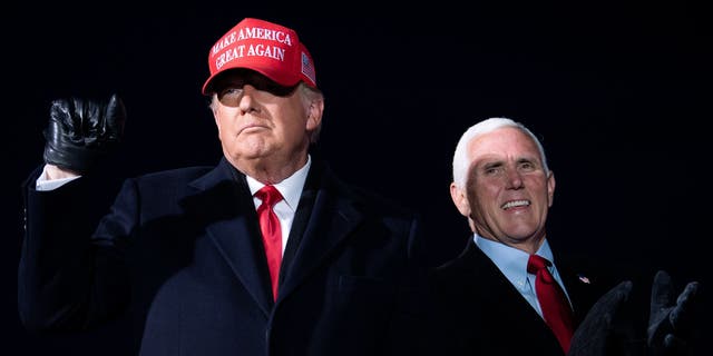 Then-President Donald Trump arrives with then-Vice President Mike Pence for a campaign rally at Cherry Capital Airport in Traverse City, Michigan on November 2, 2020. (Photo by Brendan Smialowski / AFP) (Photo by BRENDAN SMIALOWSKI/AFP via Getty Images)