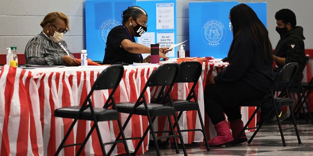 People check in as they prepare to cast their vote in the Georgia runoff election at C.T. Martin Natatorium and Recreation Center on Jan. 5, 2021 in Atlanta. 