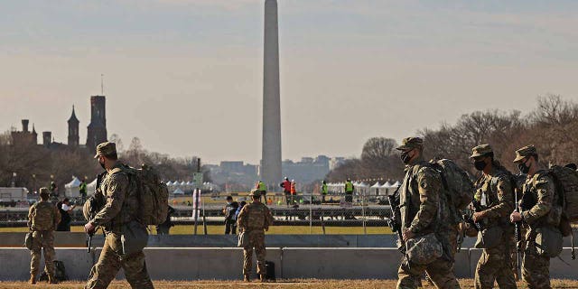 National Guard troops move along the National Mall the day after the House of Representatives voted to impeach President Donald Trump for the second time on Jan. 14.