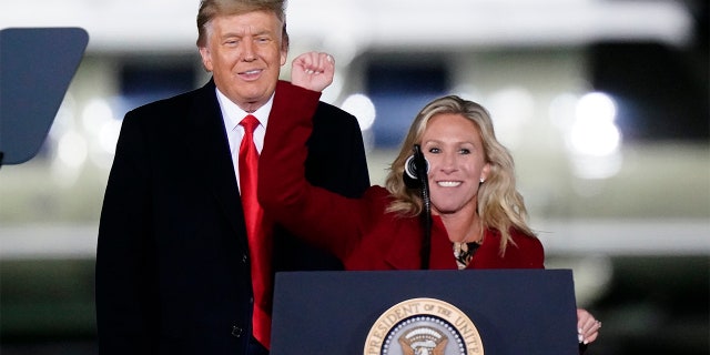 Rep. Marjorie Taylor Greene, R-Ga., speaks as President Donald Trump listens at a campaign rally in support of Senate candidates Sen. Kelly Loeffler, R-Ga., and David Perdue in Dalton, Ga., Monday, Jan. 4, 2021. (AP Photo/Brynn Anderson)
