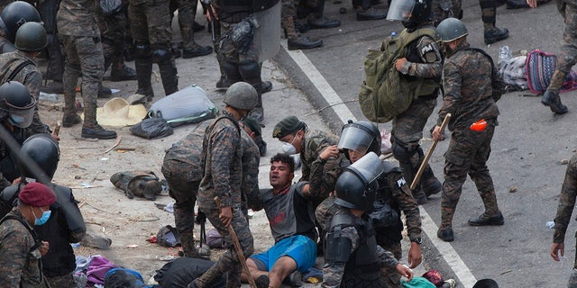 A Honduran migrant is taken in by Guatemalan soldiers after clashing with them in an attempt to reach the US border in Vado Hondo, Guatemala, Sunday, January 17, 2021. Guatemalan authorities have estimated that as many as 9,000 migrants Hondurans entered Guatemala as part of an effort to form a new caravan to reach the US border.  (AP Photo / Sandra Sebastian)