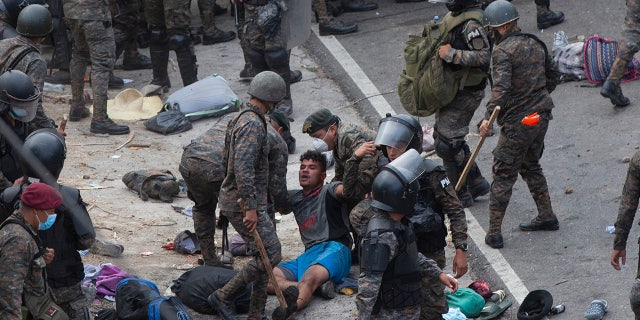 A Honduran migrant is tended to by Guatemalan soldiers after they clashed with them in a bid to reach the U.S. border in Vado Hondo, Guatemala, Sunday, Jan. 17, 2021. Guatemalan authorities estimated that as many as 9,000 Honduran migrants crossed into Guatemala as part of an effort to form a new caravan to reach the U.S. border. (AP Photo/Sandra Sebastian)