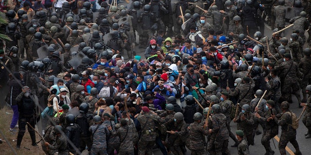 Honduran migrants clash with Guatemalan soldiers in Vado Hondo, Guatemala, Sunday, Jan. 17, 2021. Guatemalan authorities estimated that as many as 9,000 Honduran migrants crossed into Guatemala as part of an effort to form a new caravan to reach the U.S. border. (AP Photo/Sandra Sebastian)