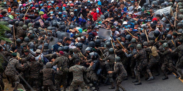 Honduran migrants clash with Guatemalan soldiers in Vado Hondo, Guatemala, Sunday, Jan. 17, 2021. Guatemalan authorities estimated that as many as 9,000 Honduran migrants crossed into Guatemala as part of an effort to form a new caravan to reach the U.S. border. (AP Photo/Sandra Sebastian)