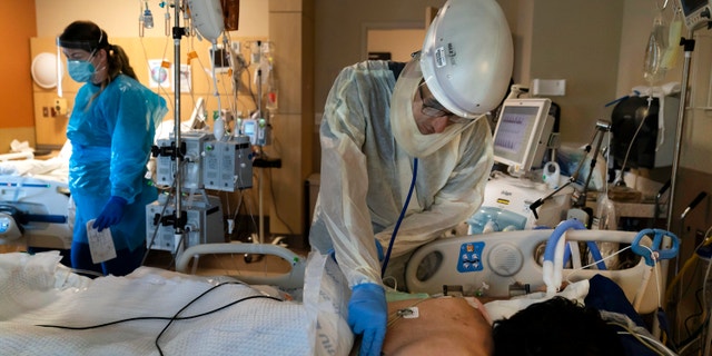 In this Nov. 19, 2020, file photo, Dr. Rafik Abdou checks on a COVID-19 patient at Providence Holy Cross Medical Center in the Mission Hills section of Los Angeles.