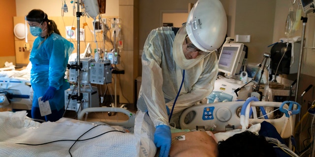 In this Nov. 19, 2020, file photo, Dr. Rafik Abdou checks on a COVID-19 patient at Providence Holy Cross Medical Center in the Mission Hills section of Los Angeles. 