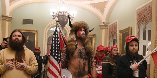 Supporters of President Trump, including QAnon backer Jake Angeli, aka Yellowstone Wolf (C), enter the US Capitol on January 6, 2021, in Washington, D.C. (Photo by SAUL LOEB/AFP via Getty Images)