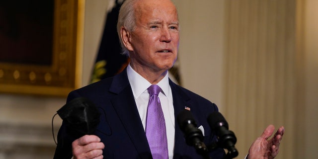 In this Jan. 26, 2021, photo, President Joe Biden holds his face mask as he speaks on COVID-19, in the State Dining Room of the White House in Washington. (AP Photo/Evan Vucci)