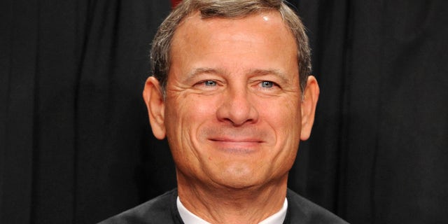 Chief Justice John Roberts smiles for the cameras as the nine members of the Supreme Court pose for a new group photograph on October, 08, 2010 in Washington, DC. (Photo by Bill O'Leary/The Washington Post via Getty Images)