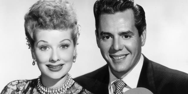 Circa 1955: Portrait of American actor and comedian Lucille Ball (1911-1989) and her husband, Cuban-born actor and bandleader Desi Arnaz (1917-1986), holding heart-shaped cutouts.