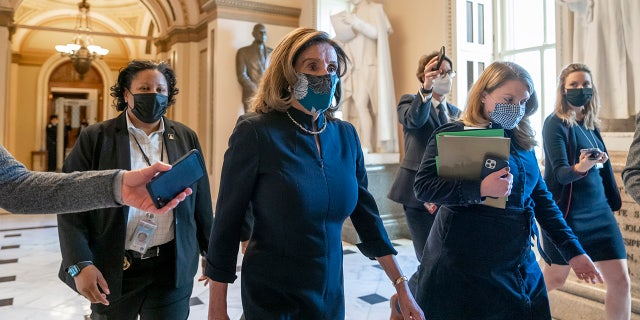 Speaker of the House Nancy Pelosi, D-Calif., returns to her leadership office after opening debate on the impeachment of President Donald Trump, at the Capitol in Washington, Wednesday, Jan. 13, 2021.