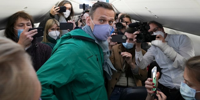 Alexei Navalny is surrounded by journalists inside the plane prior to his flight to Moscow in the Airport Berlin Brandenburg (BER) in Schoenefeld, near Berlin, Germany, Sunday, Jan. 17, 2021.