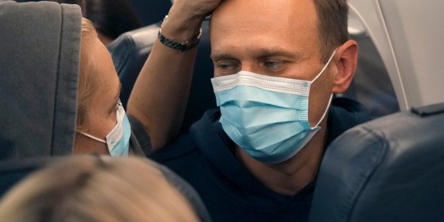 Alexei Navalny and his wife Yulia sit on the plane on a flight to Moscow, at the Airport Berlin Brandenburg (BER) in Schoenefeld, near Berlin, Germany, Sunday, Jan. 17, 2021.