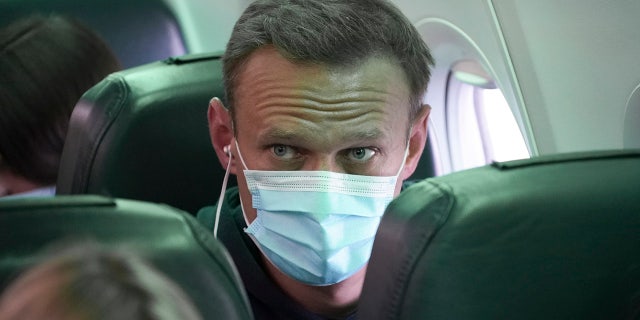 Alexei Navalny sits on the plane prior to a flight to Moscow, at the Airport Berlin Brandenburg (BER) in Schoenefeld, near Berlin, Germany, Sunday, Jan. 17, 2021. (AP Photo/Mstyslav Chernov)