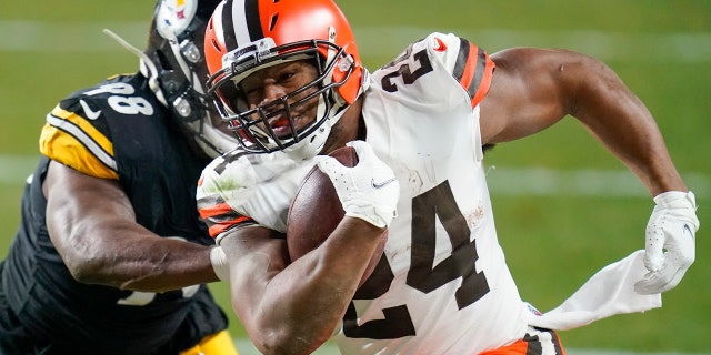 Cleveland Browns running back Nick Chubb (24) runs past Pittsburgh Steelers inside linebacker Vince Williams (98) during the first half of an NFL wild-card playoff football game, Sunday, Jan. 10, 2021, in Pittsburgh. (AP Photo/Keith Srakocic)