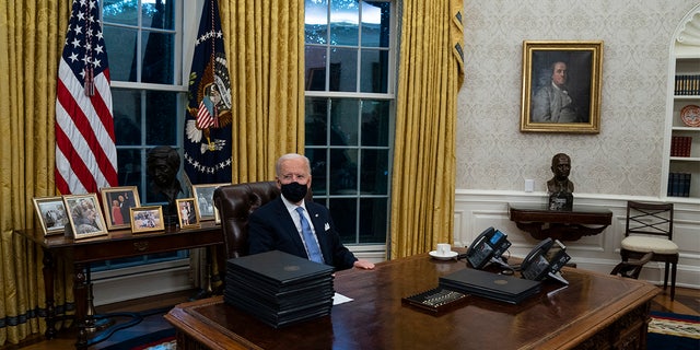 President Joe Biden signs a series of executive orders in the Oval Office of the White House, Wednesday, Jan. 20, 2021, in Washington. (AP Photo/Evan Vucci)