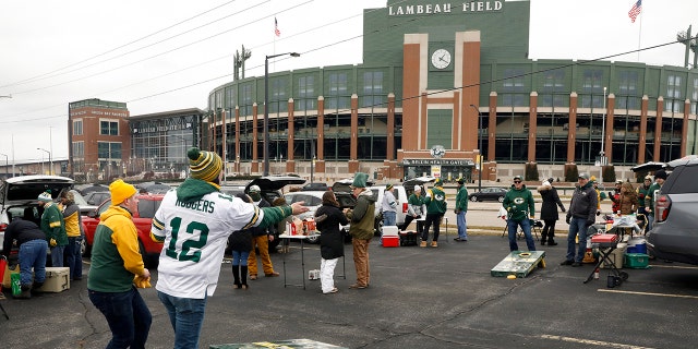 Fans toss bean bags outside of Lambeau Field before an NFL divisional playoff football game between the Los Angeles Rams and Green Bay Packers, Saturday, Jan. 16, 2021, in Green Bay, Wis. (AP Photo/Mike Roemer)