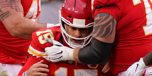 Kansas City Chiefs quarterback Patrick Mahomes (15) is helped off the field by teammate Mike Remmers, right, after getting injured during the second half of an NFL divisional round football game against the Cleveland Browns, Sunday, Jan. 17, 2021, in Kansas City. (AP Photo/Charlie Riedel)