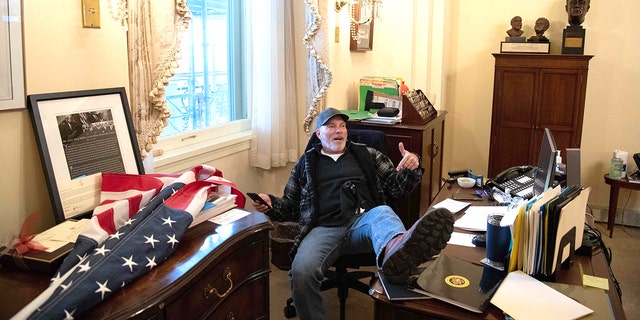 Richard Barnett, a supporter of U.S. President Donald Trump, sits inside the office of U.S. House Speaker Nancy Pelosi inside the U.S. Capitol in Washington, DC on January 6. 