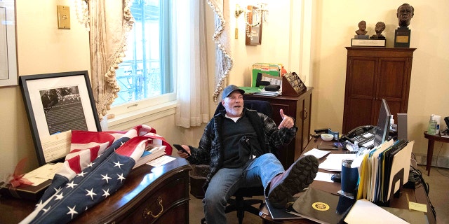 Richard Barnett, a supporter of U.S. President Donald Trump, sits inside the office of U.S. House Speaker Nancy Pelosi inside the U.S. Capitol in Washington, DC on January 6. 