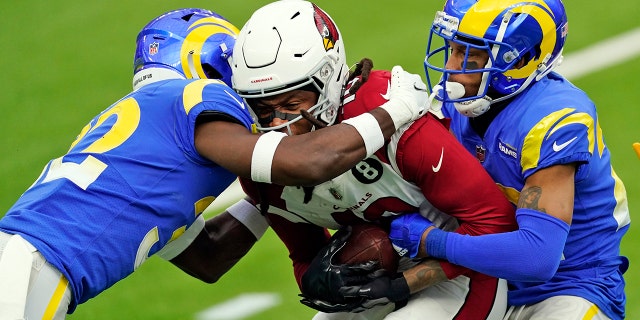 Arizona Cardinals wide receiver DeAndre Hopkins, center, is tackled by Los Angeles Rams strong safety Jordan Fuller, left, and cornerback Troy Hill during the first half of an NFL football game Sunday, Jan. 3, 2021, in Inglewood, Calif. (AP Photo/Ashley Landis)