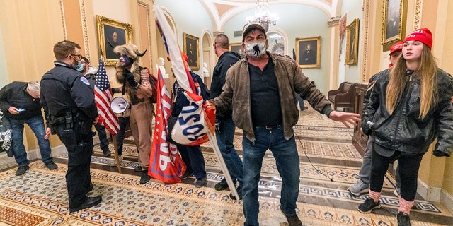 Supporters of President Donald Trump are confronted by U.S. Capitol Police officers outside the Senate Chamber inside the Capitol, Wednesday, Jan. 6, 2021 in Washington.