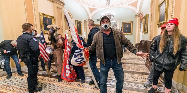 Supporters of President Trump are confronted by U.S. Capitol Police officers outside the Senate Chamber inside the Capitol, Wednesday, Jan. 6, 2021 in Washington.