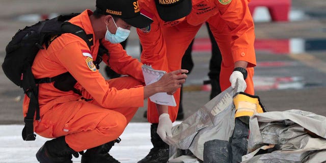 Rescuers inspect debris found in the waters around the location where a Sriwijaya Air passenger jet has lost contact with air traffic controllers shortly after the takeoff, at the search and rescue command center at Tanjung Priok Port in Jakarta, Indonesia, Sunday, Jan. 10, 2021. (Asssociated Press)