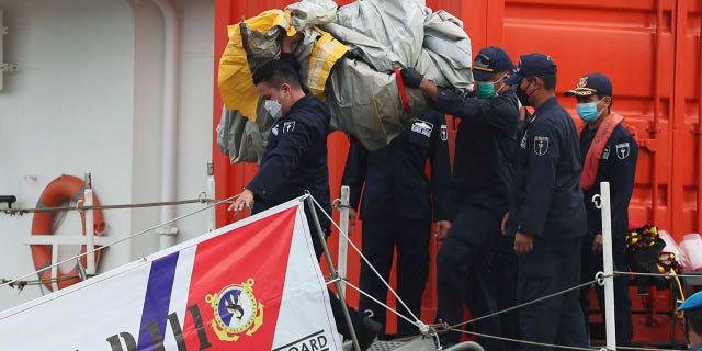 Rescuers carry debris found in the waters around the location where a Sriwijaya Air passenger jet has lost contact with air traffic controllers shortly after the takeoff, at the search and rescue command center at Tanjung Priok Port in Jakarta, Indonesia, Sunday, Jan. 10, 2021. (Associated Press)