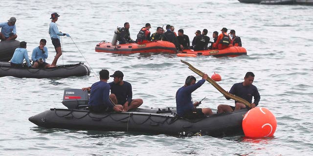 Rescuers carry debris found in the waters around the location where a Sriwijaya Air passenger jet has lost contact with air traffic controllers shortly after the takeoff, in Java Sea, near Jakarta, Indonesia, Sunday, Jan. 10, 2021. (Associated Press)