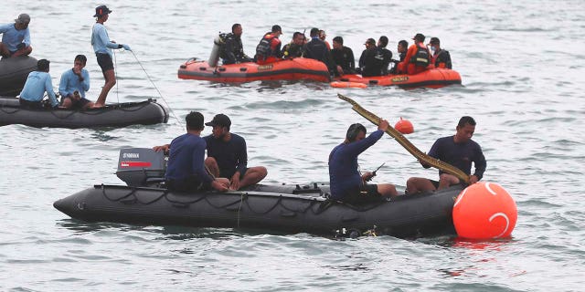 Rescuers carry debris found in the waters around the location where a Sriwijaya Air passenger jet has lost contact with air traffic controllers shortly after the takeoff, in Java Sea, near Jakarta, Indonesia, Sunday, Jan. 10, 2021. (Associated Press)