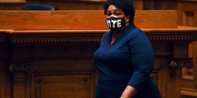 Democrat Stacey Abrams walks on Senate floor before members of Georgia's Electoral College cast their votes at the state Capitol, Monday, Dec. 14, 2020, in Atlanta. (AP Photo/John Bazemore, Pool)