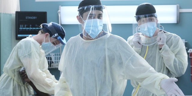 L-R: Emily VanCamp, Manish Dayal and Matt Czuchry in full PPE during the premiere episode of 'The Resident.'