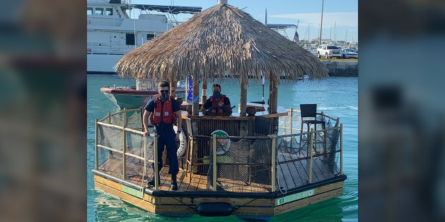 Photos show USCG members at the "helm" of the floating bar and on deck as they brough it back to harbor.