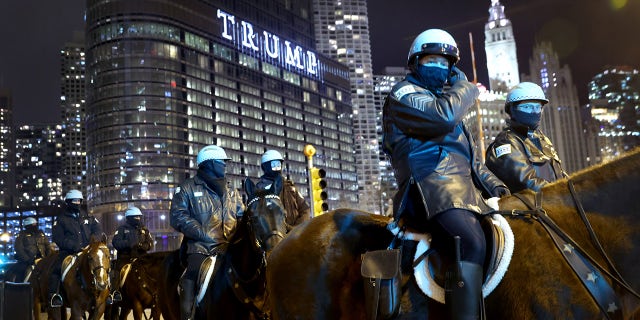 Police keep watch as a small group of demonstrators protest near Trump Tower on January 07, 2021 in Chicago, Illinois. (Photo by Scott Olson/Getty Images)