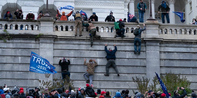 Protesters climb the west wall of the U.S. Capitol on Wednesday, Jan. 6, 2021, in Washington, D.C. (AP Photo/Jose Luis Magana)