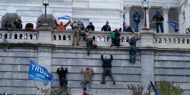 Supporters of President Donald Trump climb the west wall of the U.S. Capitol on Wednesday, Jan. 6, 2021, in Washington.