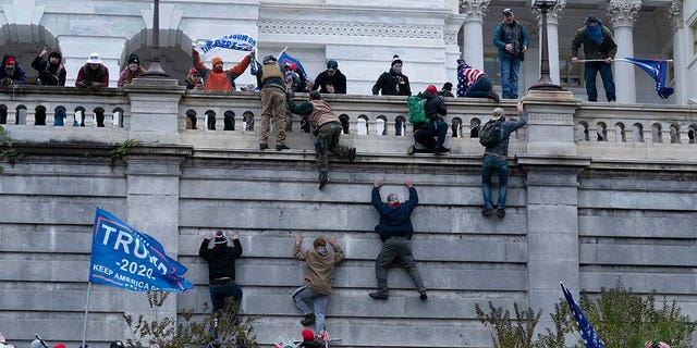 Pro-Trump supporters climb the west wall of the U.S. Capitol on Jan. 6, 2021, in Washington.