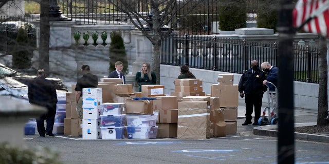 People wait for a moving van after boxes were moved out of the Eisenhower Executive Office building inside the White House complex on Thursday. (AP)