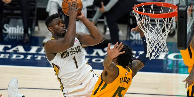 New Orleans Pelicans forward Zion Williamson (1) shoots as Utah Jazz center Derrick Favors (15) defends during the first half of an NBA basketball game Tuesday, Jan. 19, 2021, in Salt Lake City. (AP Photo/Rick Bowmer)