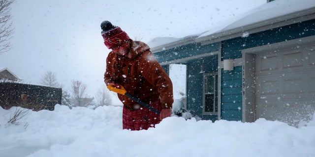 Tim Ahlman shovels snow outside his home in Bellemont, Ariz. on Monday. (AP)