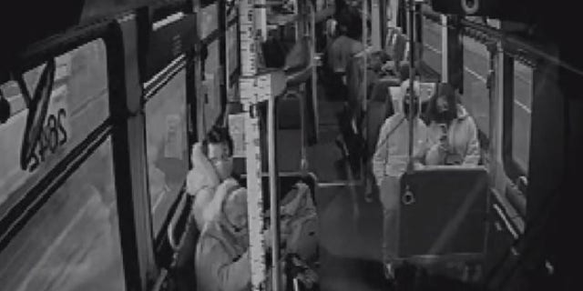 This still image taken from surveillance video aboard a Metro bus shows a man kicking a woman in the side of her head.