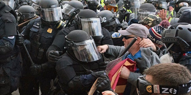 Capitol police officers in riot gear push back demonstrators on Wednesday, Jan. 6, 2021, in Washington.