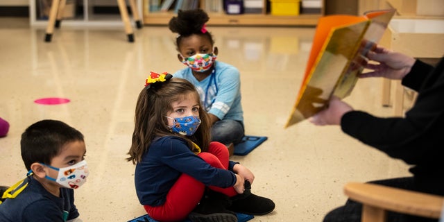 Pre-kindergarten students listen as their teacher reads a story at Dawes Elementary in Chicago, on Jan. 11. Chicago Public Schools wanted thousands of K-8 teachers and staff to return to classrooms Monday to prepare for the resumption of in-person learning, but now that return date has been delayed. (AP/Chicago Sun-Times)