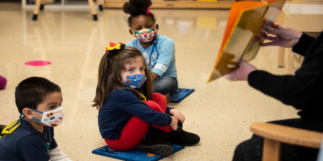 Pre-kindergarten students listen as their teacher reads a story at Dawes Elementary in Chicago, on Jan. 11. Chicago Public Schools wanted thousands of K-8 teachers and staff to return to classrooms Monday to prepare for the resumption of in-person learning, but now that return date has been delayed. (AP/Chicago Sun-Times)