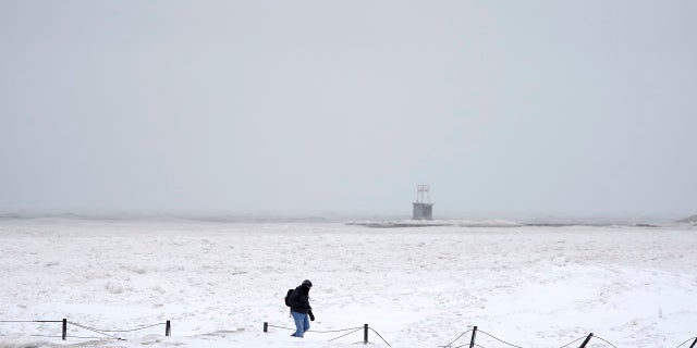 A lone man walks along a frozen section of North Ave. beach on Lake Michigan north of downtown Chicago on Tuesday. (AP)