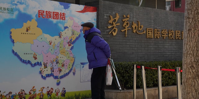 An elderly Chinese man looks at map of Chinese showing its different ethnic groups and the slogan "Ethnic Unity" 在北京, China Monday, 一月. 11. (AP Photo/Ng Han Guan)