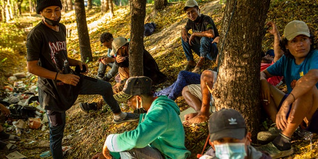 Honduran migrants rest on the roadside as they try to advance past checkpoints set up by the Guatemalan police in Zacapa, Tuesday, Jan. 19, 2021. (AP Photo/Oliver de Ros)